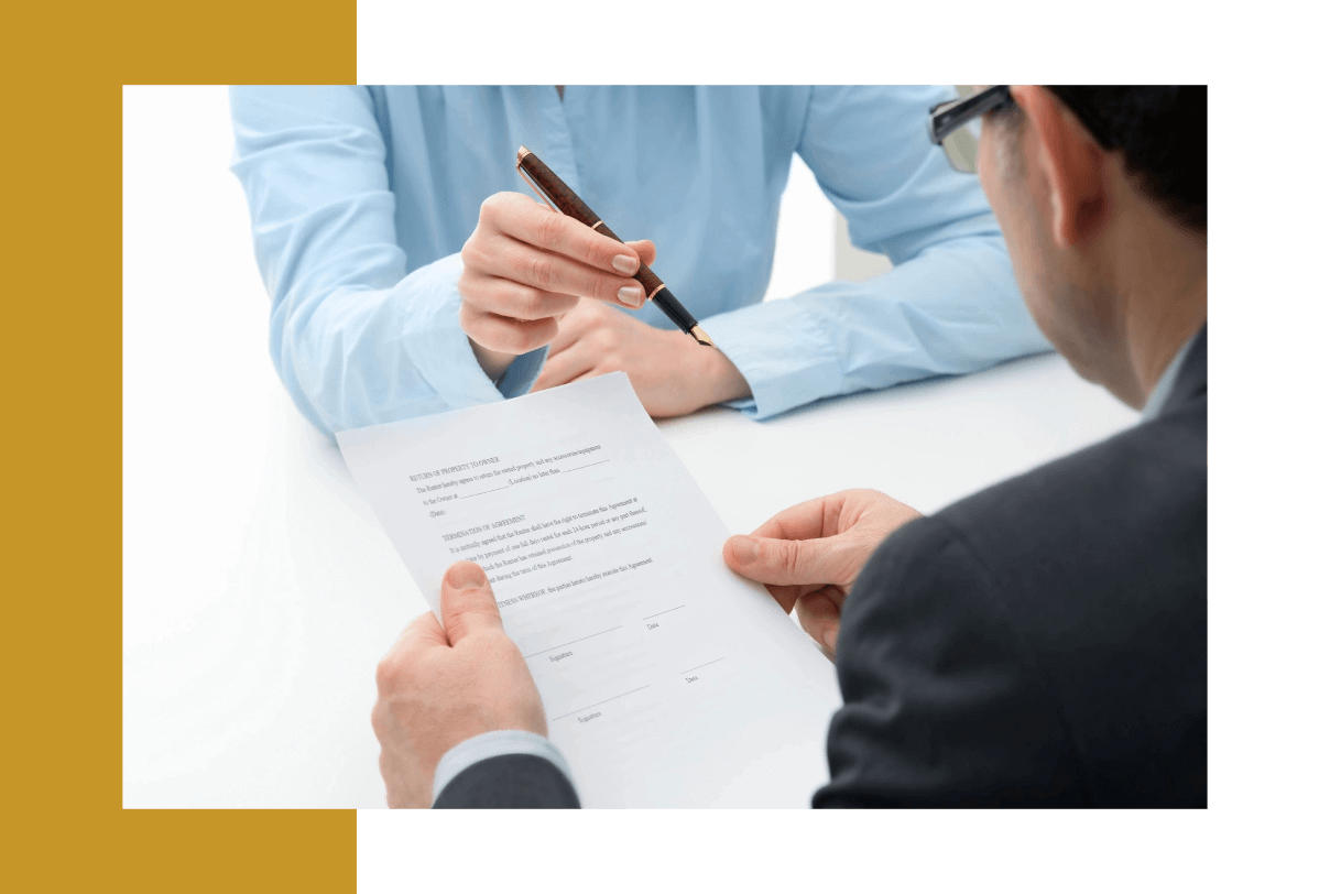 Two people are sitting at a table with papers.